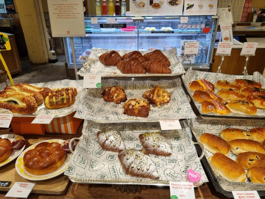Trays of cornetto, almond cornetto and pistachio cornetto at Amor Napoli bakery in Anguk, with price cards