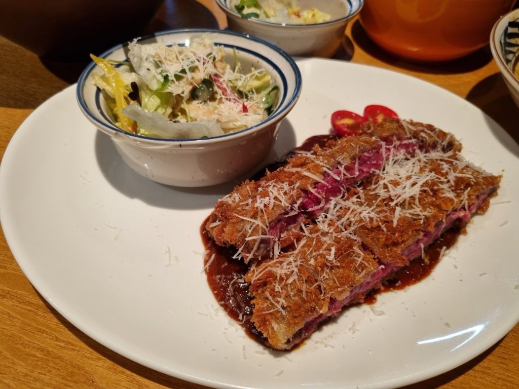 Rare gyukatsu beef cutlet with demi-glace sauce and grated cheese at Kaden