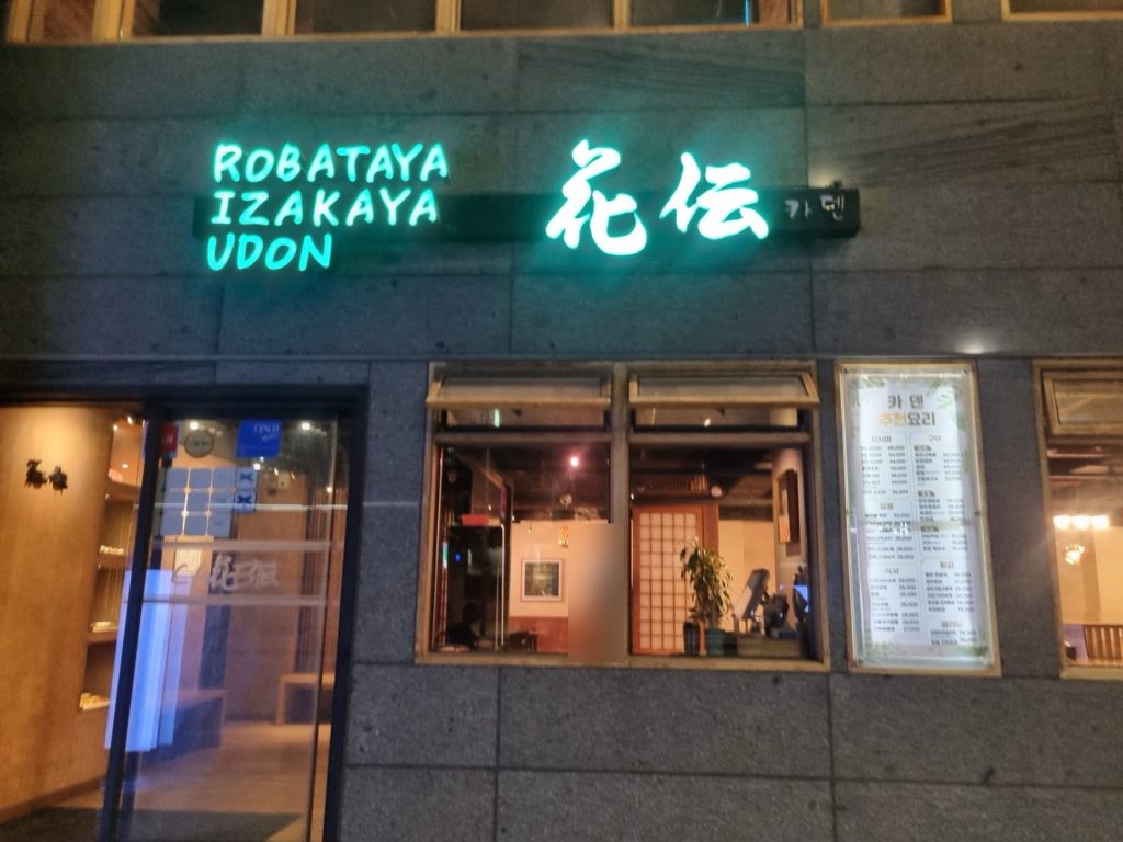 Kaden restaurant storefront at night with Robataya Izakaya Udon neon sign
