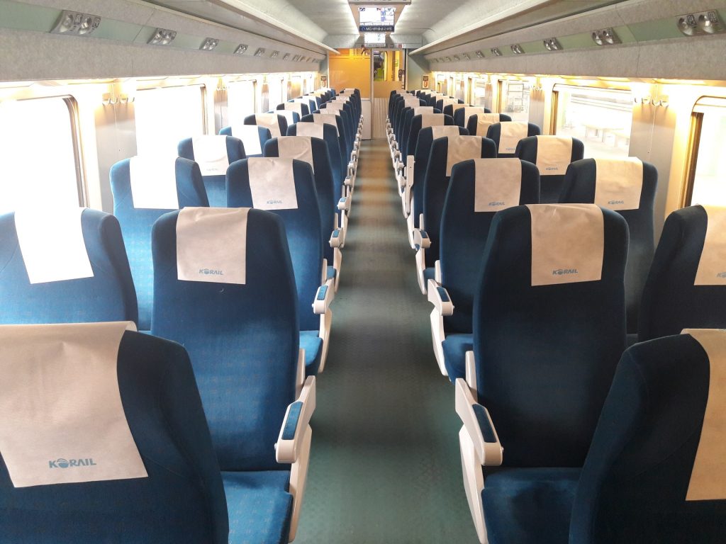 Rows of blue seats inside a KTX train car