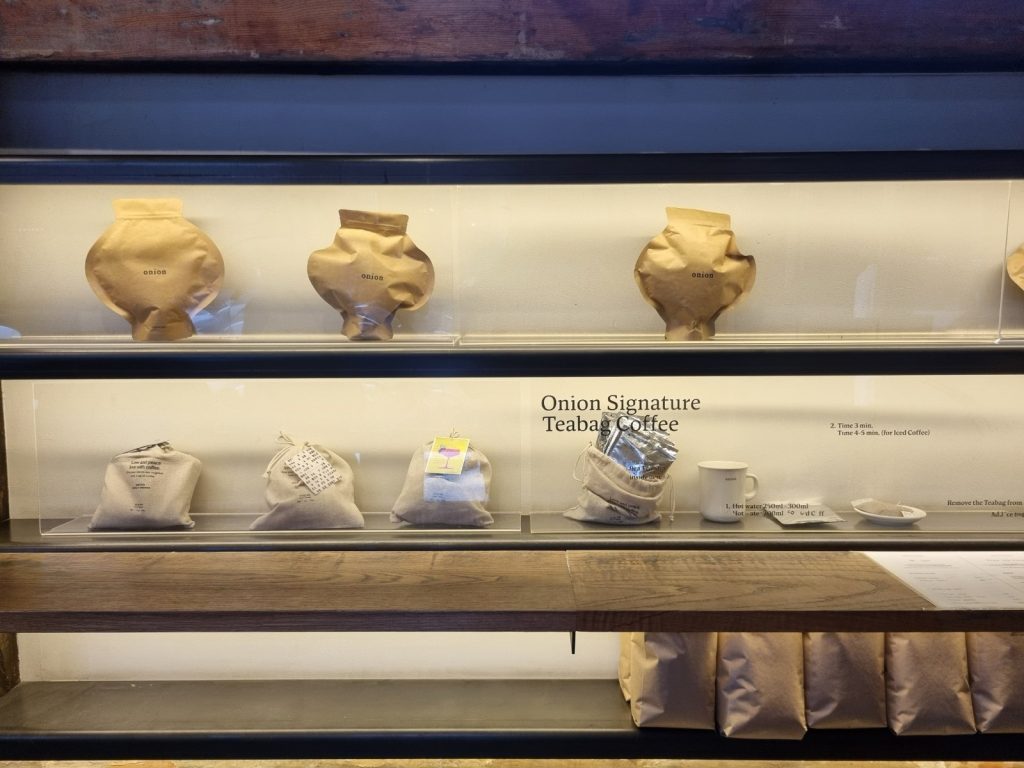 Onion coffee bean bags and signature teabag coffee displayed on shelves at Onion Anguk