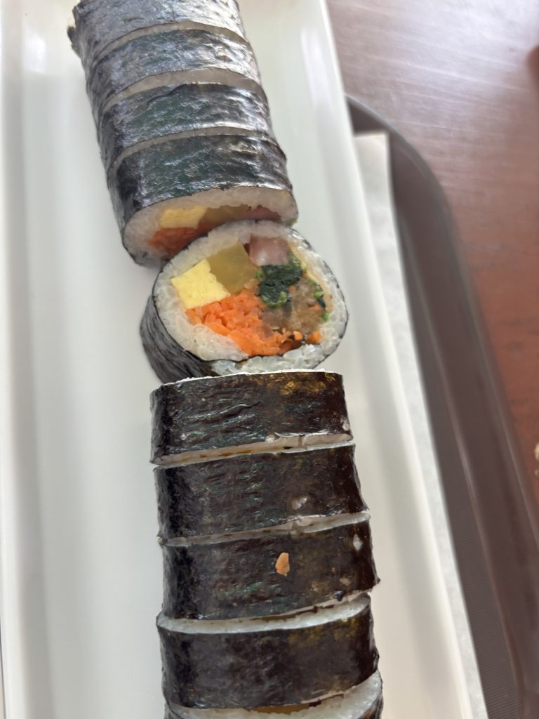 Classic Korean gimbap cross-section with egg, ham, spinach and carrot